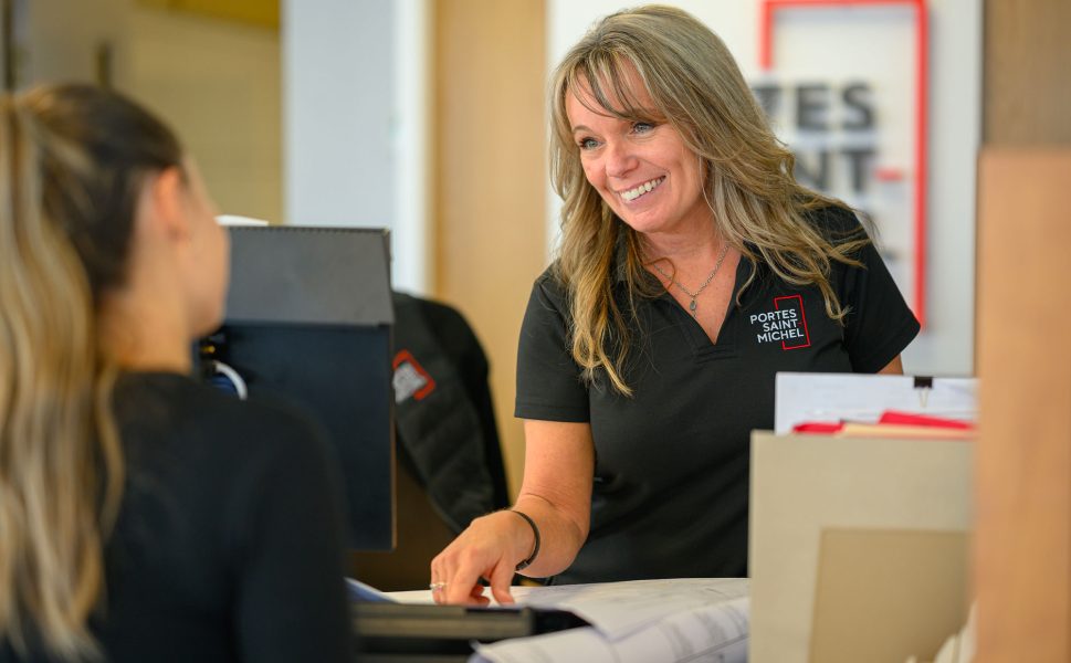 Conseillère du service client de Portes Saint-Michel accueillant une cliente avec le sourire