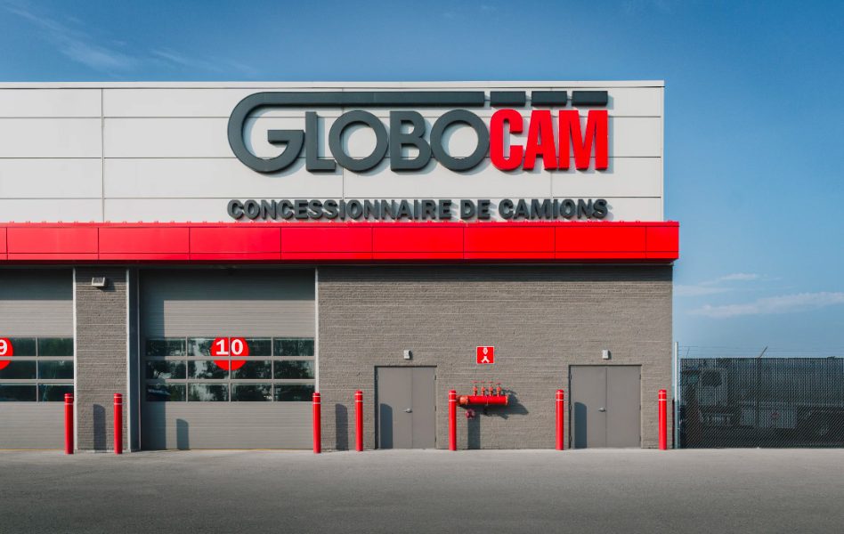 Façade du concessionnaire de camions Globocam au Québec avec enseigne et portes de garage numérotées