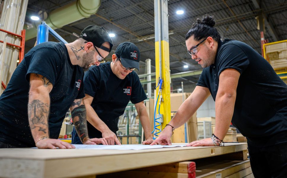 Équipe de production Portes Saint-Michel examinant les plans de fabrication de portes dans l’usine