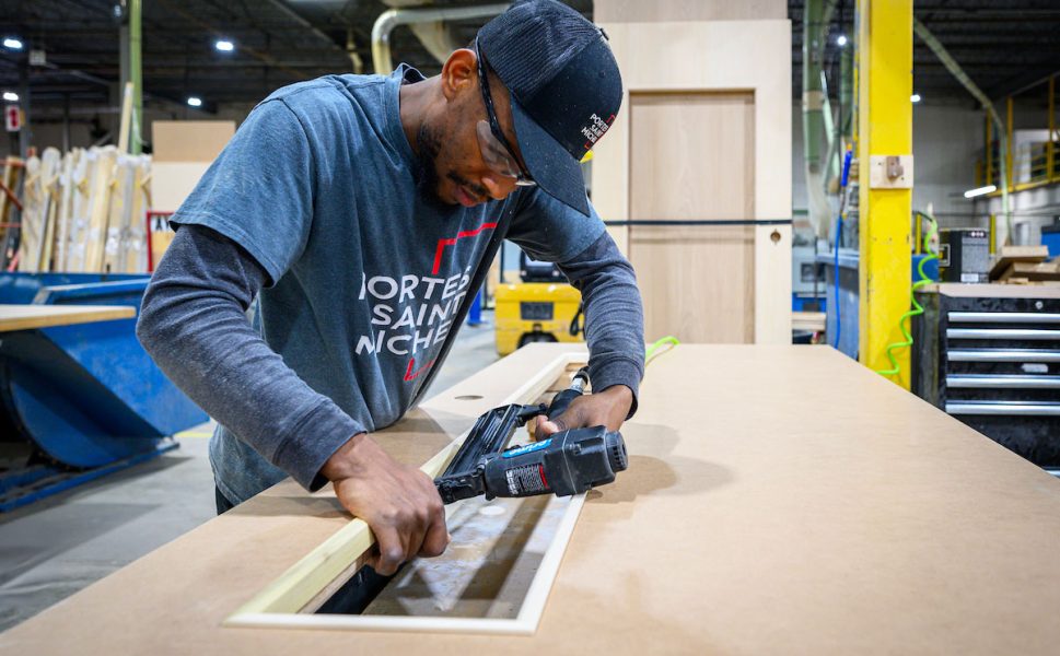 Ouvrier Portes Saint-Michel en fabrication d’une porte intérieure dans l’usine