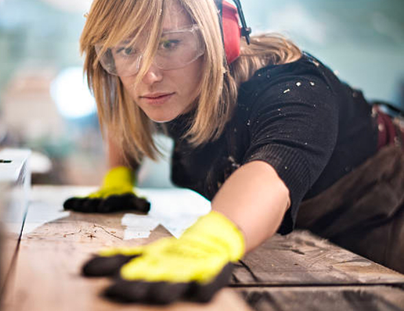 Femme ébéniste travaillant le bois lors de la fabrication d’une porte
