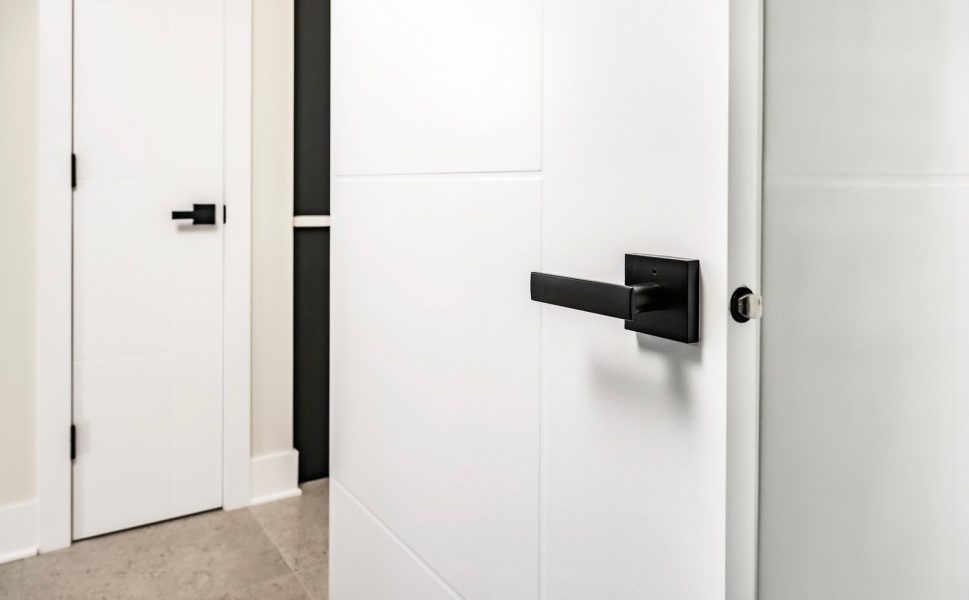 Porte intérieure blanche moderne avec poignée noire carrée au design épuré